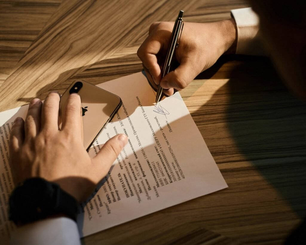 Professional signing legal documents for property investment, representing the importance of proper documentation for Karnataka agriculture land purchases